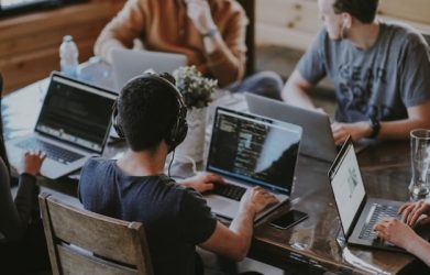 Programmers collaborating on laptops in coworking space