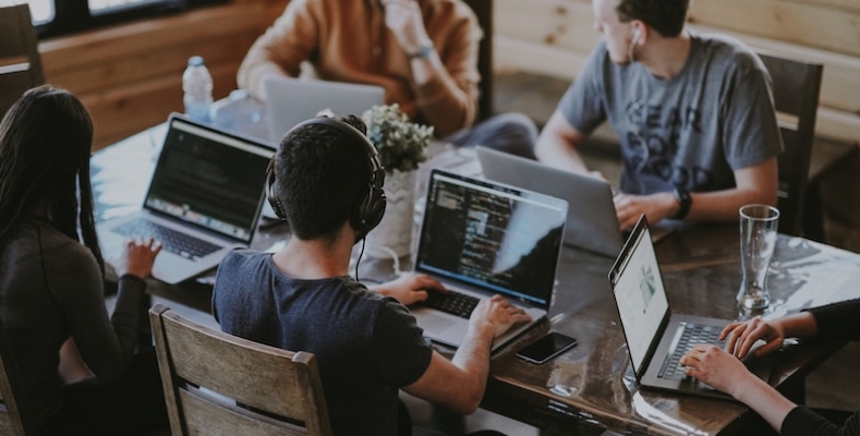 Programmers collaborating on laptops in coworking space