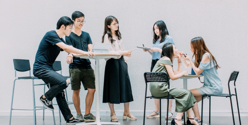 Young adults chatting at high and low tables